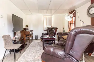 a living room with a leather couch and a television at cozy room with private bathroom in Arlington