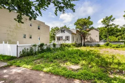 an old white house with a fence and a yard at cozy room with private bathroom in Arlington
