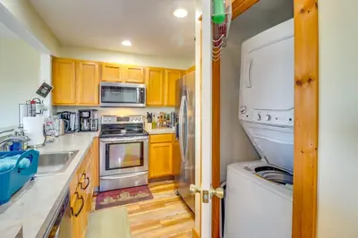 a kitchen with wooden cabinets and a white refrigerator at Tannersville Rental Near Camelback Ski Resort! in Tannersville
