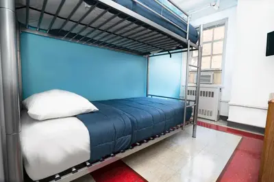 a bunk bed in a room with a blue wall at West Side YMCA in New York