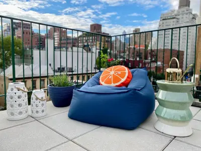 a blue bean bag chair with an orange in it on a balcony at Lofty & Bright Greenwich Getaway w Private Rooftop in New York