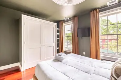 a bedroom with a large white bed and two windows at Lofty & Bright Greenwich Getaway w Private Rooftop in New York