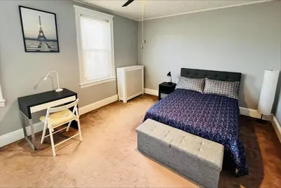 a bedroom with a bed and a desk and a bed sidx sidx sidx at Cozy Home close to New York City in Fairview