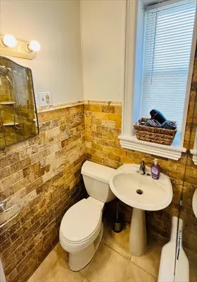 a bathroom with a toilet and a sink at Cozy Home close to New York City in Fairview