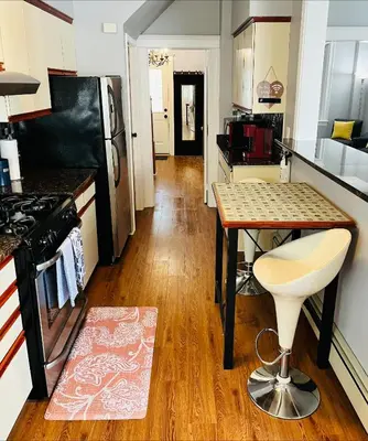 a kitchen with a table and a stool in it at Cozy Home close to New York City in Fairview