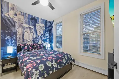 a bedroom with a bed and two windows at 10Min to NYC - 2BR/2.5Bath-3Beds-Free Parking-No Chores in Hoboken