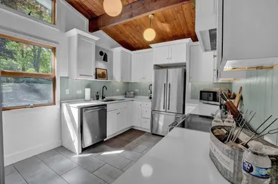 a kitchen with white cabinets and stainless steel appliances at Lakefront, Pool, Hot Tub, Boats, Game Room, Pets in Bushkill