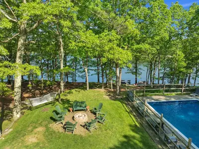 a backyard with a pool and chairs and a swing at Lakefront, Pool, Hot Tub, Boats, Game Room, Pets in Bushkill