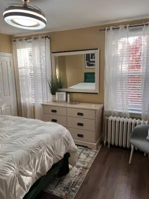 a bedroom with a bed and a dresser with a mirror at Cozy on the Hill in Wilmington