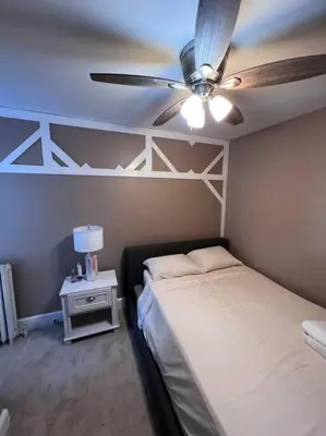 a bedroom with a bed and a ceiling fan at Cozy on the Hill in Wilmington