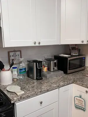 a kitchen with white cabinets and a counter top with appliances at Cozy on the Hill in Wilmington