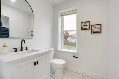 a white bathroom with a toilet and a window at Family-Friendly Hatfield Home 3 Mi to Downtown! in Hatfield