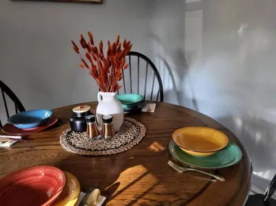 a wooden table with plates and a vase on it at Home away from home in Pottstown