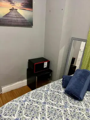 a bedroom with a bed with a mirror and a bed sidx sidx sidx at Room in a 2 Bedrooms apt. 10 minutes to Time Square! in West New York