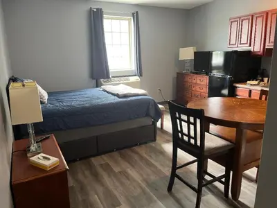 a bedroom with a bed and a table and a kitchen at Gamble Farm Inn and Suites in Jersey Shore