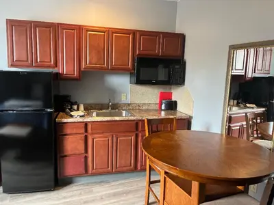 a kitchen with a table and a black refrigerator at Gamble Farm Inn and Suites in Jersey Shore
