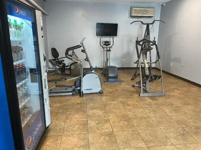 a gym with several exercise bikes and a television at Gamble Farm Inn and Suites in Jersey Shore