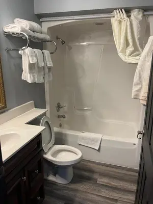 a bathroom with a toilet and a tub and a sink at Gamble Farm Inn and Suites in Jersey Shore