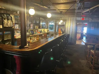 a bar in a pub with a long counter and chairs at Gamble Farm Inn and Suites in Jersey Shore