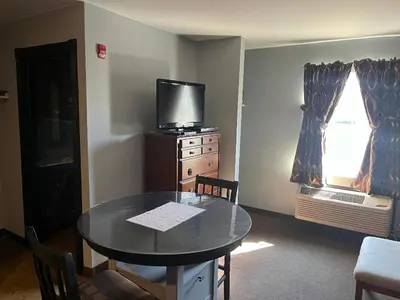 a dining room with a table and a tv at Gamble Farm Inn and Suites in Jersey Shore