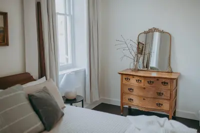 a bedroom with a bed and a dresser with a mirror on it at 1900's Historic Lancaster School House in Willow Street