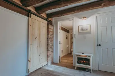 a living room with a brick wall and a fireplace at 1900's Historic Lancaster School House in Willow Street
