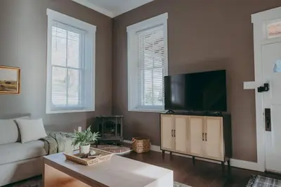 a living room with a couch and a flat screen tv at 1900's Historic Lancaster School House in Willow Street