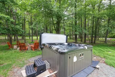 a barbecue grill and chairs in a park at Weekend at Bernie's! *Pet friendly!* **Hot tub** in Long Pond
