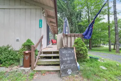 a sign on the side of a house with a welcome to a weekend of excuses at Weekend at Bernie's! *Pet friendly!* **Hot tub** in Long Pond