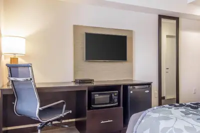a bedroom with a desk with a television and a chair at Sleep Inn Philadelphia Center City in Philadelphia