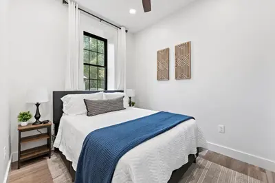 a white bedroom with a bed and a window at Riverview in Port Clinton - Apt A in Port Clinton