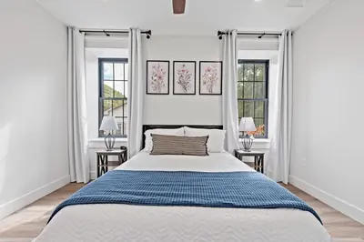 a white bedroom with a large bed and two windows at Riverview in Port Clinton - Apt. B in Port Clinton