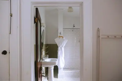 a white bathroom with a sink and a mirror at The North Branch Inn in North Branch