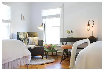 a bedroom with a piano and a couch and a chair at The North Branch Inn in North Branch