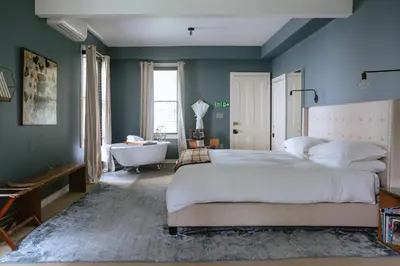 a bedroom with a bed and a bath tub and a sink at The North Branch Inn in North Branch