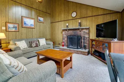a living room with a couch and a fireplace at Fire Pit Arrowhead Lake Vacation Rental! in Pocono Lake