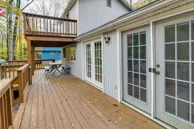 a large wooden deck with a balcony on a house at Fire Pit Arrowhead Lake Vacation Rental! in Pocono Lake