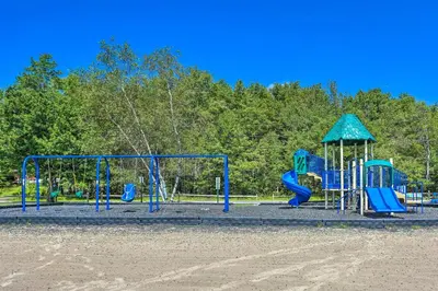 a playground with blue equipment in a park at Fire Pit Arrowhead Lake Vacation Rental! in Pocono Lake