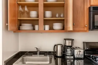 a kitchen with a sink and a counter with dishes at Fidi 1br w doorman wd nr south st seaport NYC-1306 in New York