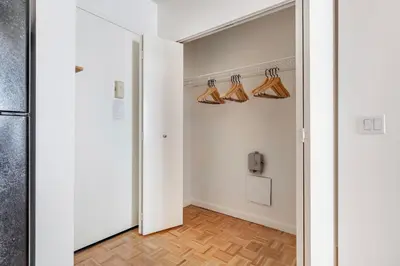 a hallway with a door to a room with hangers at Fidi 1br w doorman wd nr south st seaport NYC-1306 in New York