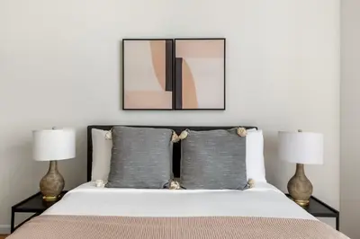 a bedroom with a bed with two lamps at Fidi 1br w doorman wd nr south st seaport NYC-1306 in New York