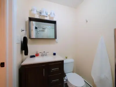 a bathroom with a sink and a toilet and a mirror at Stylish 3 bed, minutes to NYC! in Jersey City