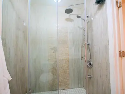 a shower with a glass door in a bathroom at Stylish 3 bed, minutes to NYC! in Jersey City