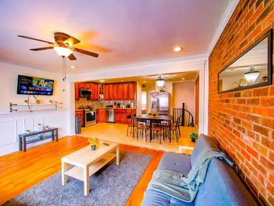 a living room with a couch and a brick wall at Stylish 3 bed, minutes to NYC! in Jersey City