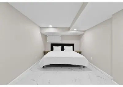 a white bedroom with a bed in a white room at Epic Spa & Play Retreat NYC EWR Sleeps 30! in Bayonne