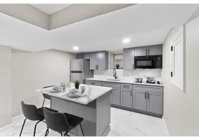 a kitchen with a counter and two chairs in it at Epic Spa & Play Retreat NYC EWR Sleeps 30! in Bayonne