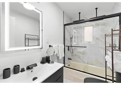 a white bathroom with a sink and a shower at Epic Spa & Play Retreat NYC EWR Sleeps 30! in Bayonne