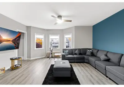 a living room with a couch and a ceiling fan at Epic Spa & Play Retreat NYC EWR Sleeps 30! in Bayonne