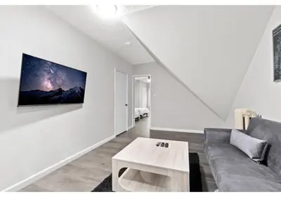 a living room with a couch and a tv on a wall at Epic Spa & Play Retreat NYC EWR Sleeps 30! in Bayonne