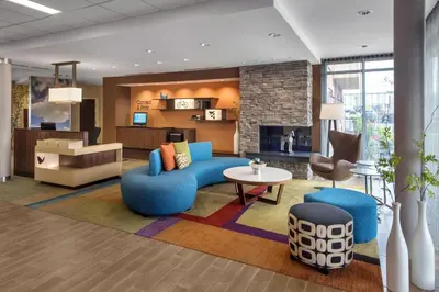 a living room with a blue couch and a table at Fairfield Inn & Suites by Marriott New Castle in New Castle